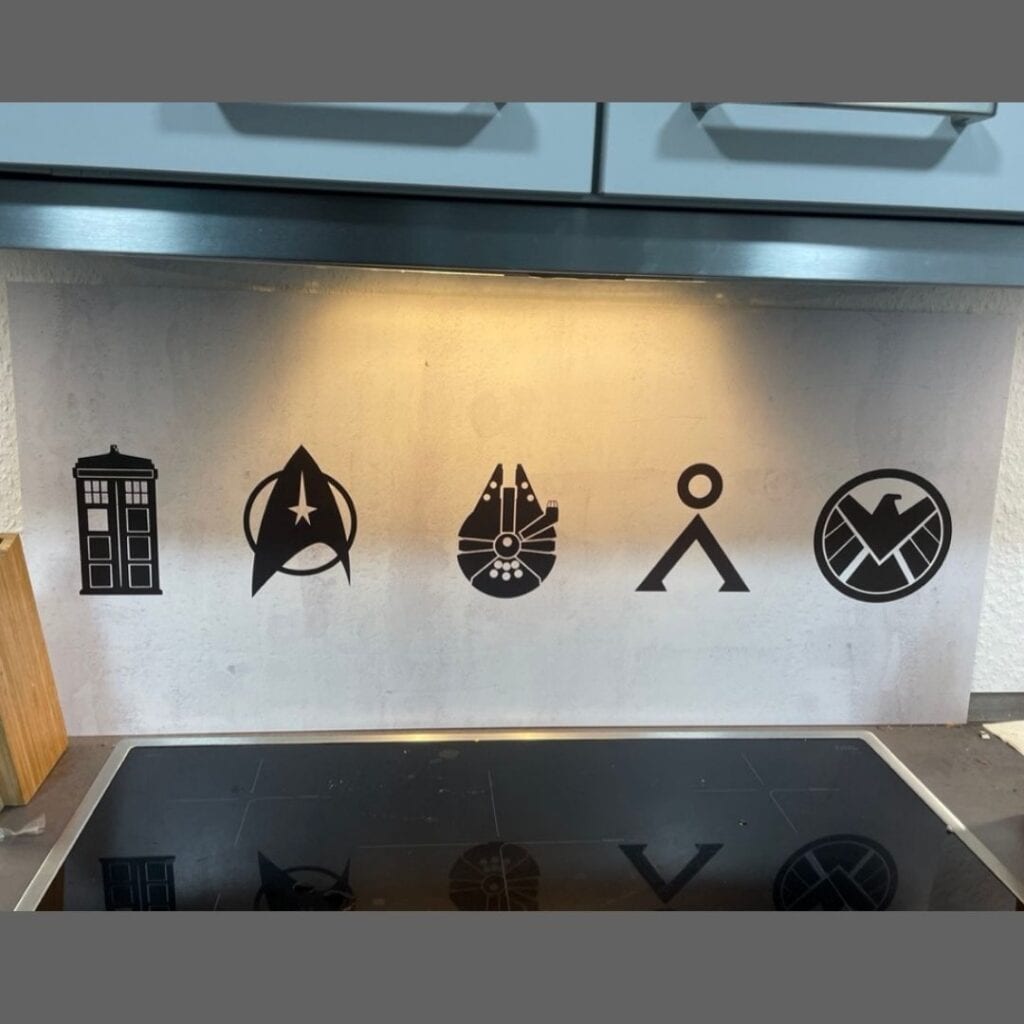 Ein Spritzschutz für hinter den Herd mit Symbolen aus Science Fiction-Filmen und Serien