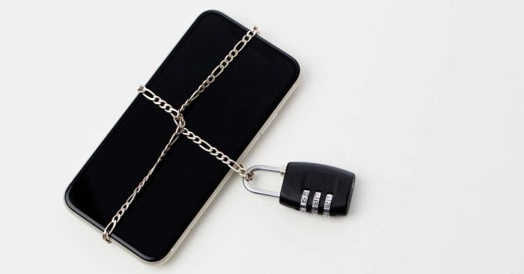 Ein Handy, gesperrt durch eine Kette und ein Zahlenschloss